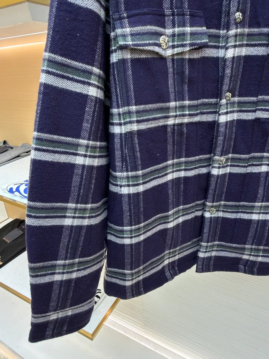 Chrome Hearts Contrast Checkered Lapel Shirt Jacket ●Item No.: 1682307-C05 ●Fabric: Cotton Fabric ●Technology: Made on Positioning Cutting Machine ●Color: Blue and White Plaid ●Version: Fitted ●Weight: Approximately 1030g ●Size: S-M-L-XL ●Description: This Louis Vuitton plaid shirt-style jacket is made of high-count wool blended brushed fabric imported from Italy. It is woven into a classic blue, white and green plaid pattern through yarn-dyed jacquard technology. The yarn is first dyed and then woven to ensure that the plaid color is clear and not easy to fade. The fabric has been pre-shrunk, and the shrinkage rate is controlled within 1%. The body pieces are cut using laser positioning, and the check pattern alignment error does not exceed 0.3cm. The double patch pockets on the front are sewn with welted three-dimensional sewing technology, and the edges of the pockets are padded for a crisper shape. The placket is equipped with custom metal engraved snap buttons, which accurately echo the plaid pattern of the body; the shoulders are made of seamless epaulette splicing technology, and the wiring is smooth and seamless. The double-needle locking technology on the cuffs and hem enhances durability. The overall stitch length is maintained at 7 needles per centimeter, and the wiring is even and smooth. The lining is made of breathable cotton and linen blended materials, taking into account texture and wearing comfort, fully demonstrating the brand's exquisite clothing technology. The overall wiring is straight and delicate, the fabric is comfortable and soft, and the color is consistent without color difference. It can be matched with the same style to create a fashionable look and control various occasions. Customized accessories, complete with three standards, same style for men and women!